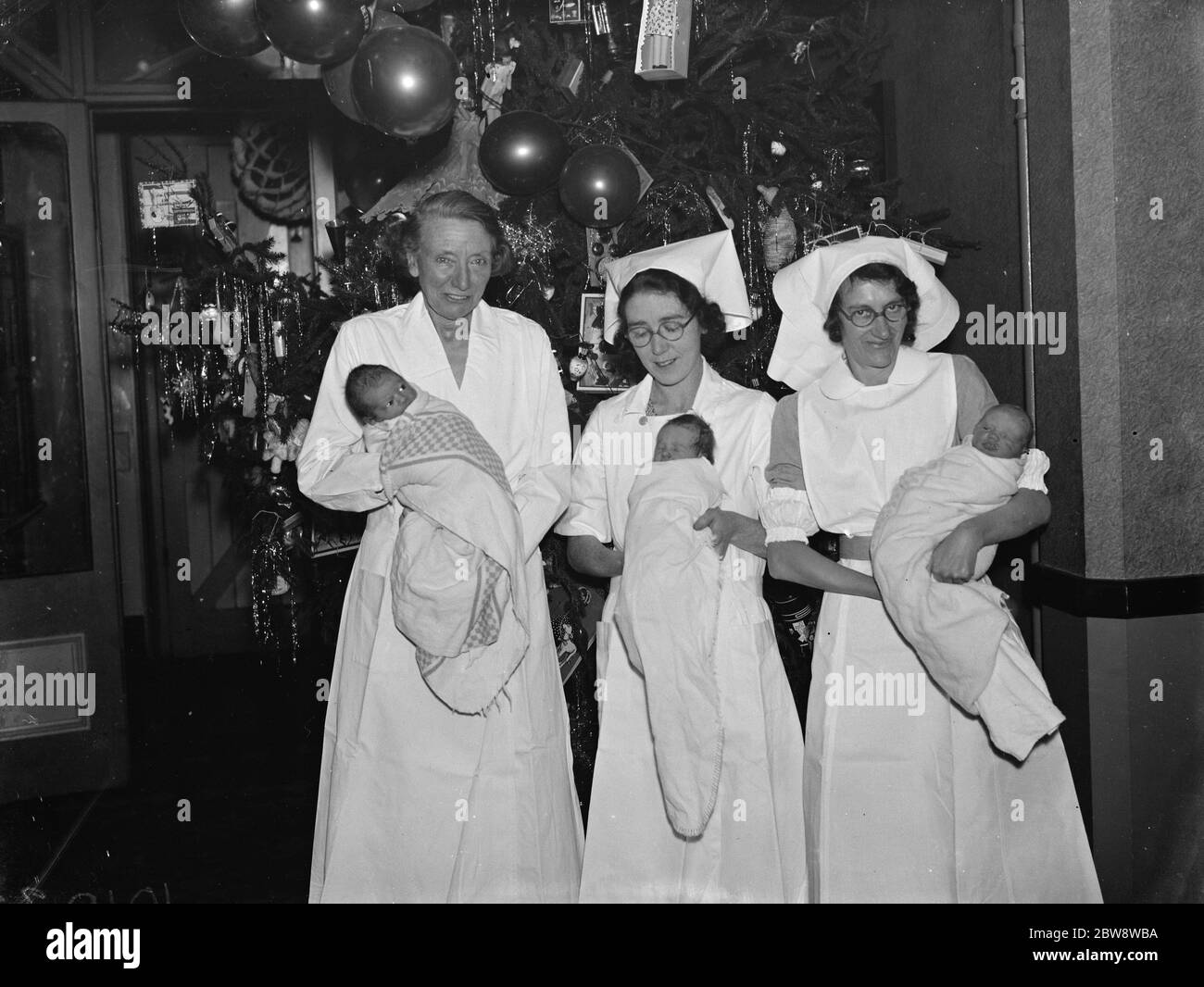 Christmas at the Russel Stoneham Hospital in Crayford . Nurses hold newborn babies . 1938 Stock Photo