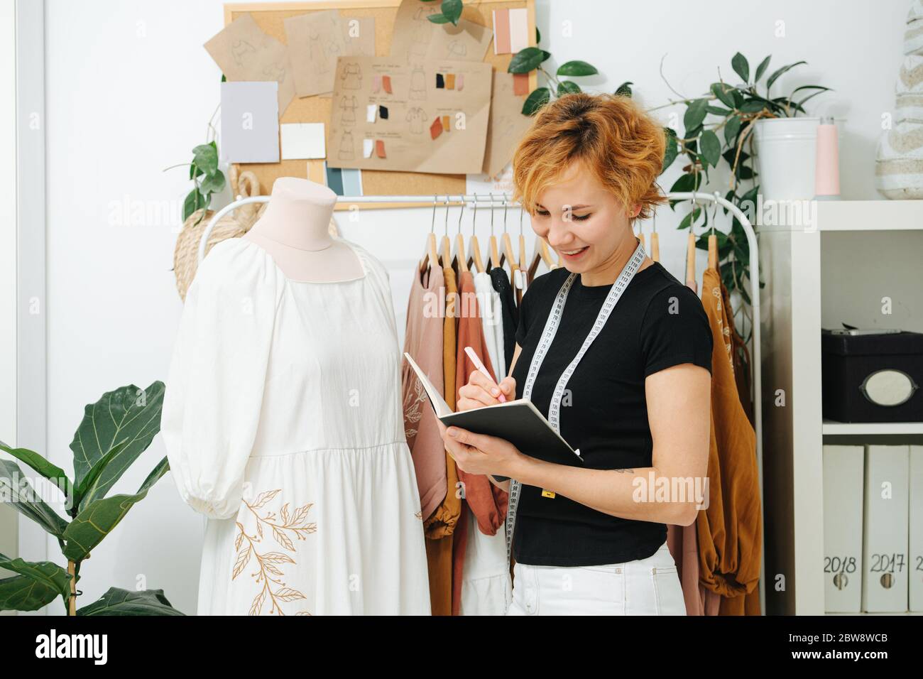 Dressmaker in a writes in notepad, she is working on a new