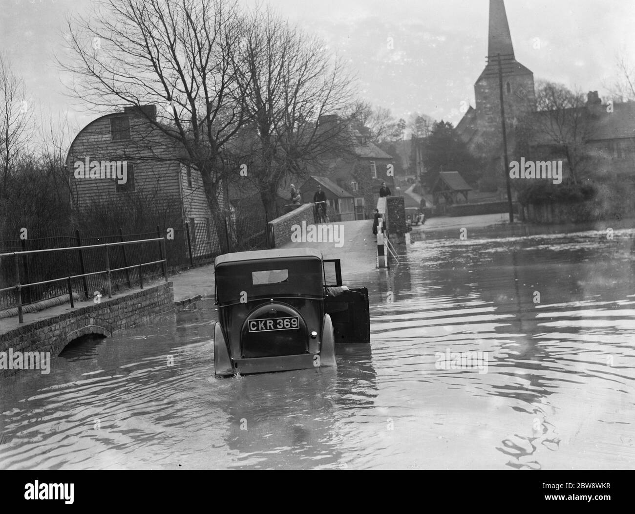 Flooding in Eynsford , Kent . Motorist tries to navigate through the flooded street . 1937 Stock Photo