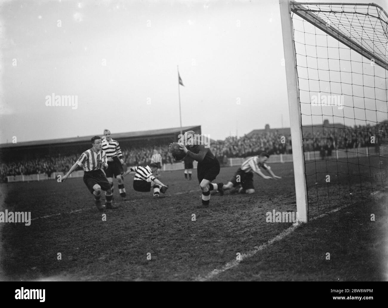 Dartford versus Darlington football match . Action in front of the goal , the goalkeeper makes a save . 1937 Stock Photo