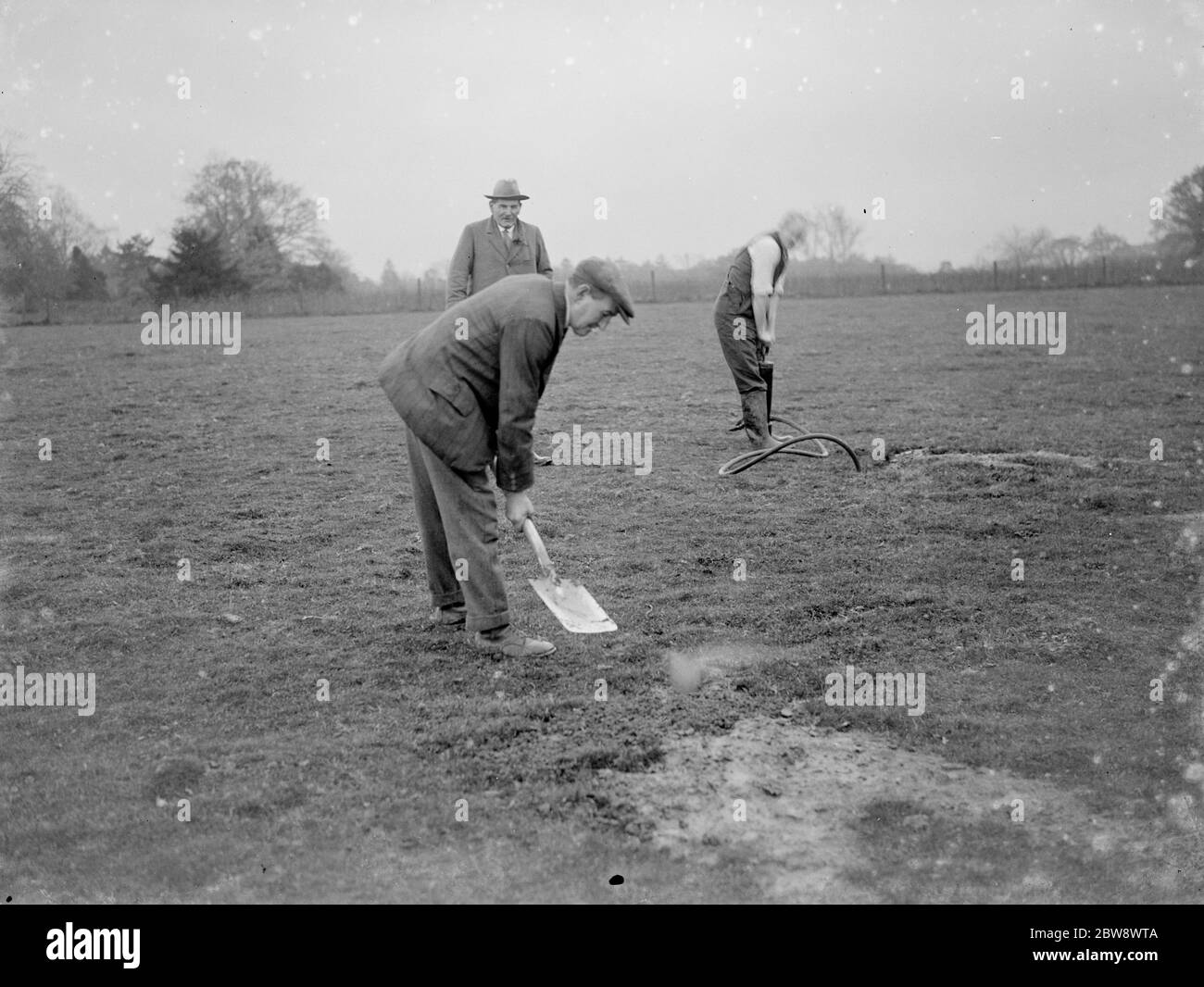 A pest controller fills in the rabbit burrows after injecting in the poisonous Cyanogas . 1936 Stock Photo