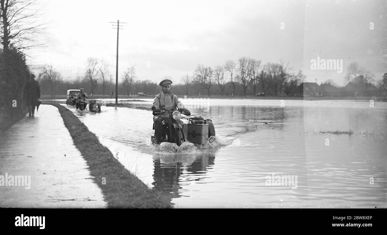 An AA Patrolman risks the flooded road on his motorbike . 1936 Stock Photo