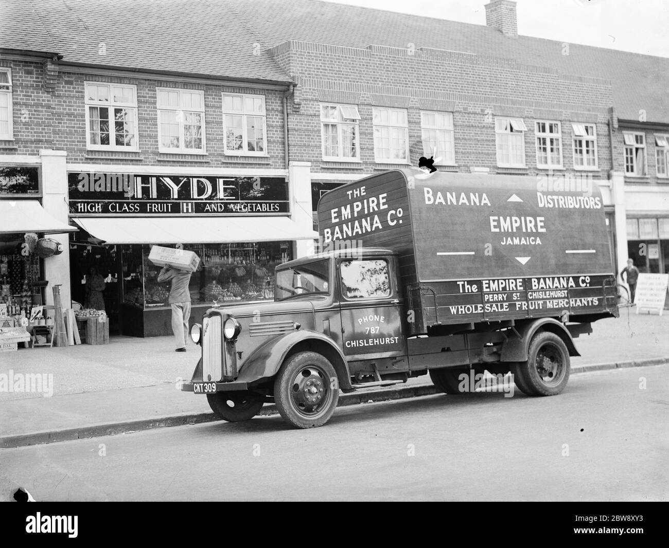 A Bedford truck belonging to The Empire Banana Company , the wholesale fruit merchant based in Chislehurst , Kent . The truck is making a delivery to Hyde , the greengrocer . 1936 . Stock Photo