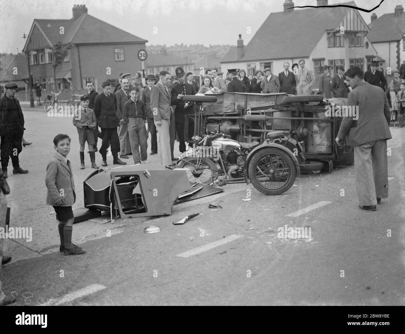Crowd gathers to inspect the aftermath of a crash between a car and a sidecar motorbike in Rochester , Kent . 1939 Stock Photo