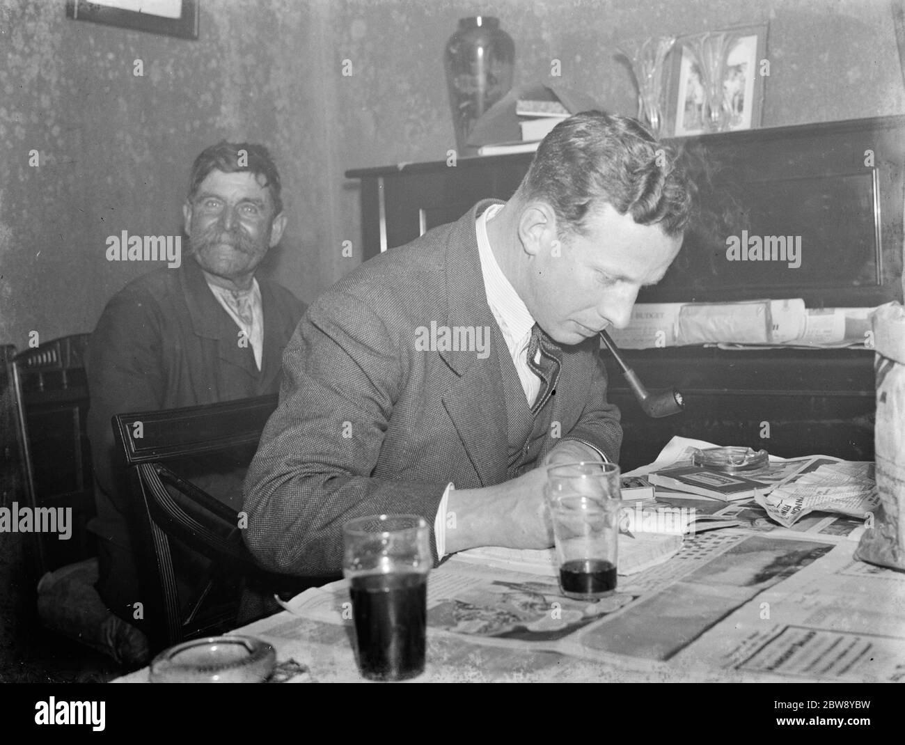 Paying in night at the Rat and Sparrow Club in Eynsford , Kent . Mr F Foreman the secretary is tallying up the rat 's tails on the table . Member are being paid according to the number of rat 's tails in their catch . Mr Charlie Meadows sits in the background . 1939 Stock Photo