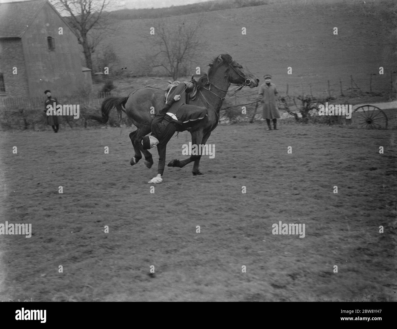 Horse trick riding in Eynsford , Kent . Hanging from the stirrup and picking an object from the floor . 1939 Stock Photo