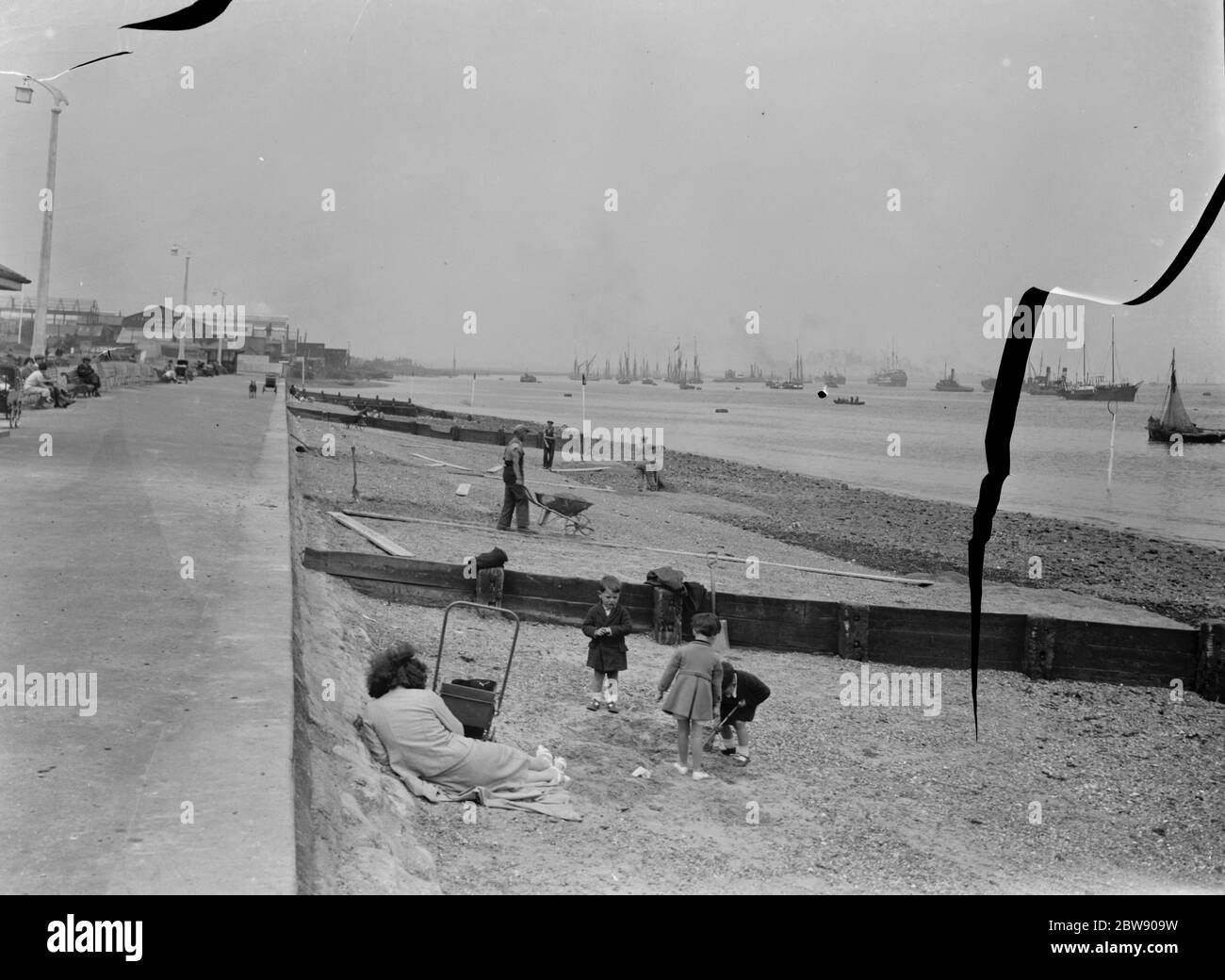 Members of the public relax on the opened beaches of the river Thames in Gravesend , Kent , during low tide . 1937 . Stock Photo