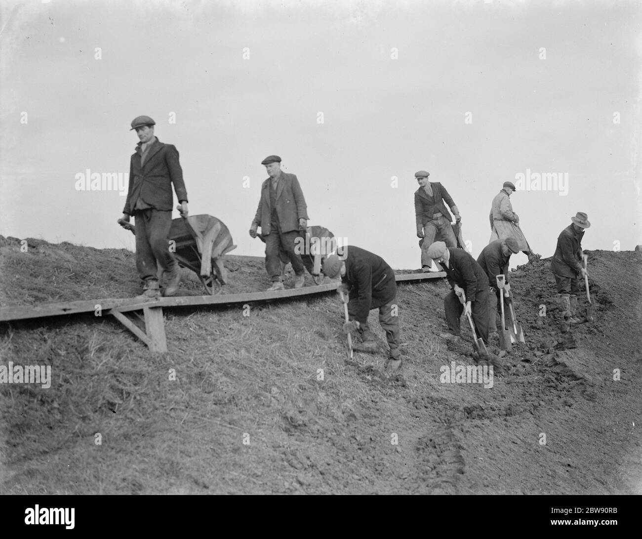 Workers increasing the river defences and doing repairs on the river wall and embankment at Dartford creek . 1939 Stock Photo