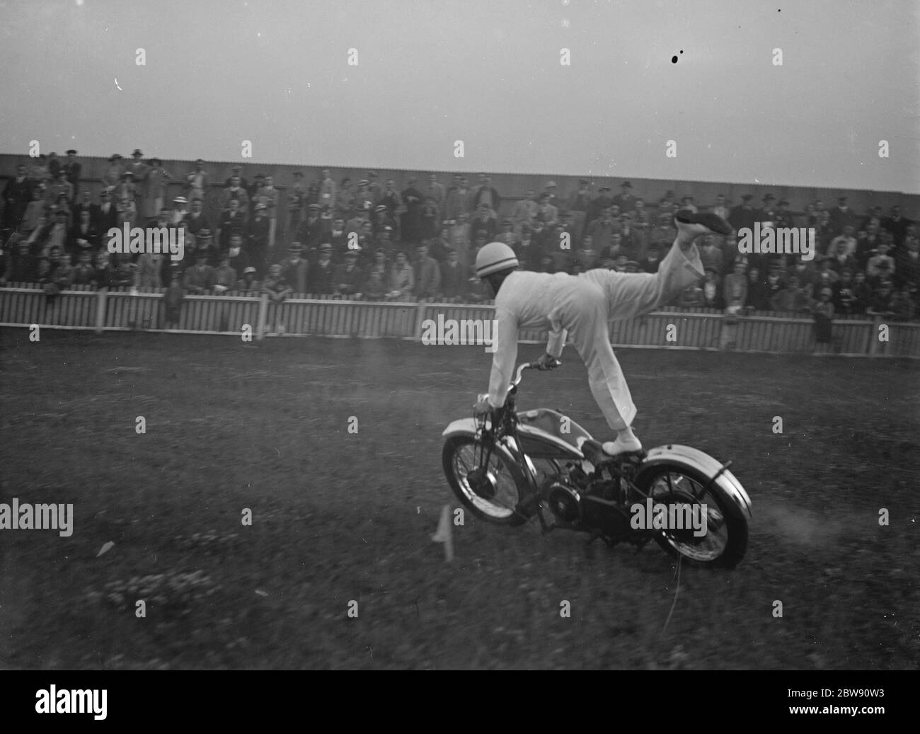 The Gravesend and District Motor Cycle Gymkhana in Kent . World champion Jim Hayhurst performs stunts on his bike in front of spectators . 19 June 1939 Stock Photo