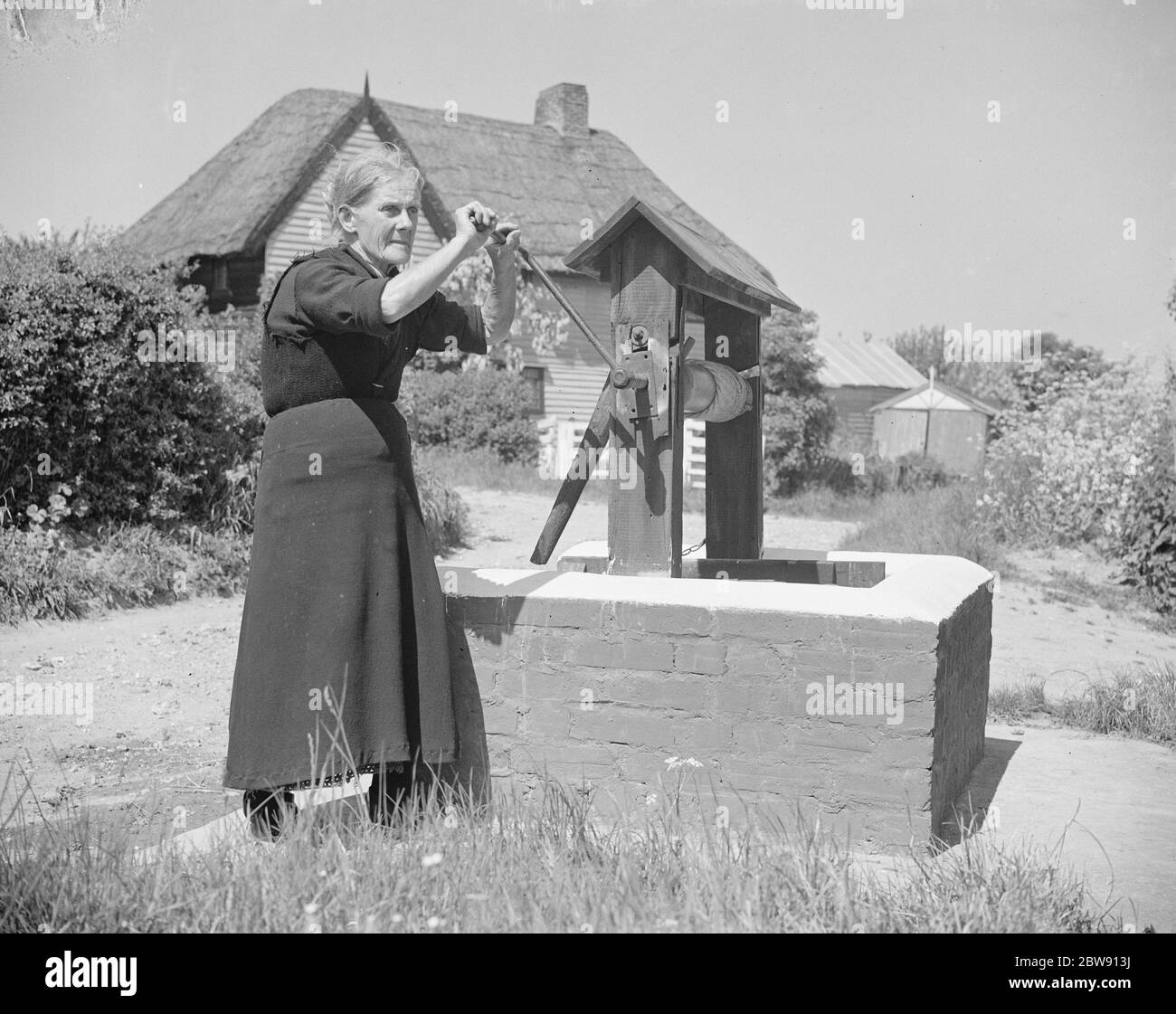 Rebecca Munday using a water well in Deans Bottom , Kent . 1939 . Stock Photo
