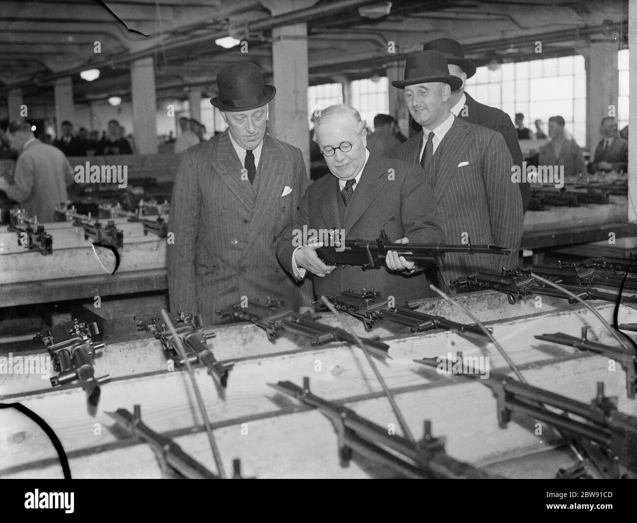 Sir Howard Kingsley Wood , the Secretary of State for Air , visiting the Vickers factory in Crayford , Kent . Sir Kingsley holds a Vickers K-GO twin mounted machine gun . 1939 Stock Photo