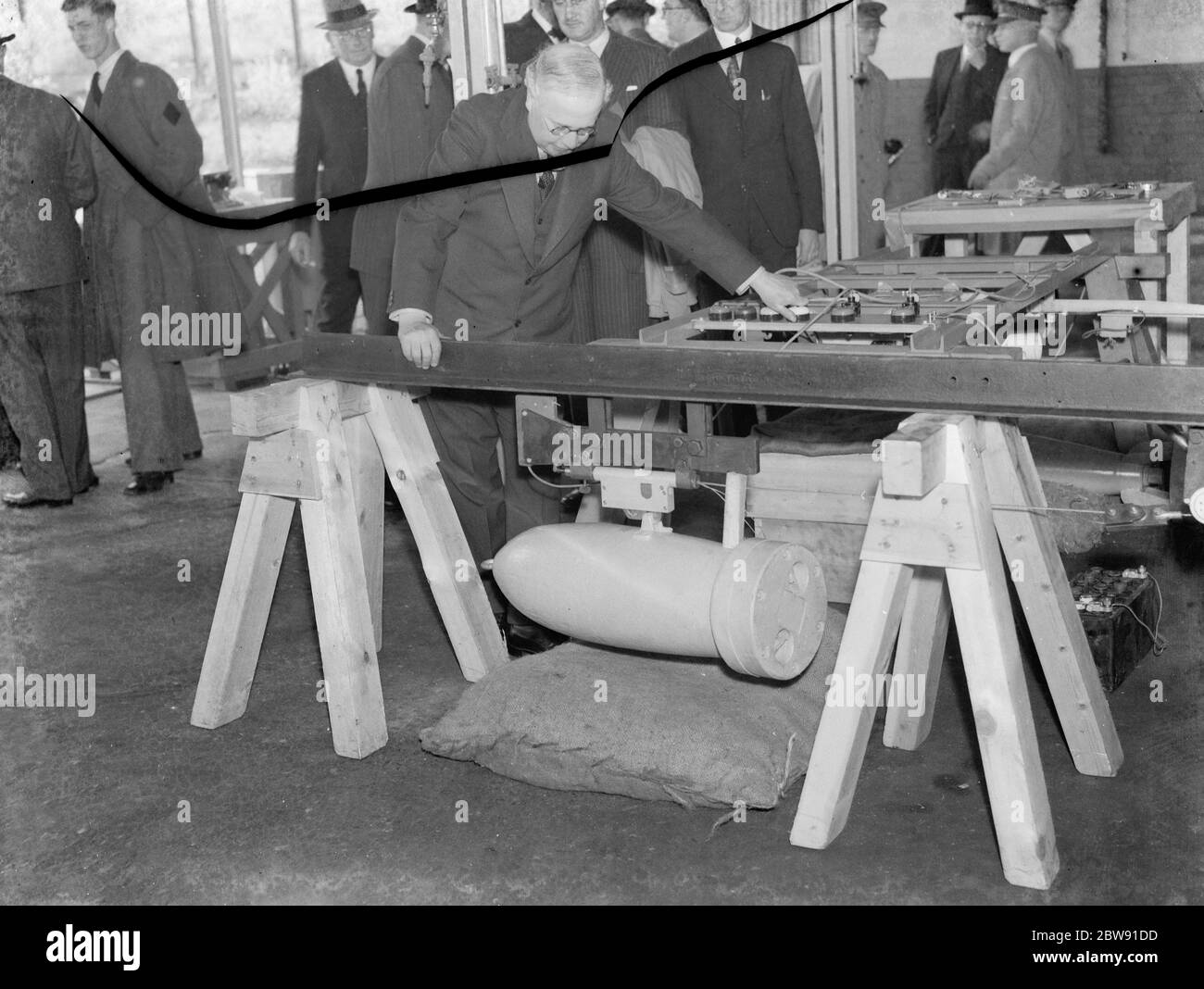 Sir Howard Kingsley Wood the Secretary of State for Air visiting the Vickers factory in Crayford , Kent . Sir Kingsley looks over a bomb release mechanism . 1939 Stock Photo