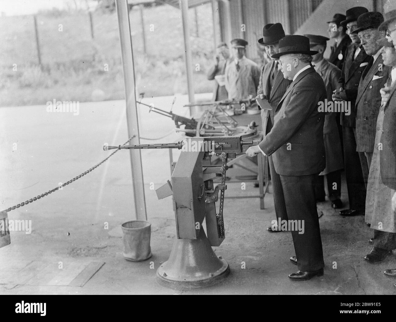 Sir Howard Kingsley Wood , the Secretary of State for Air , visiting the Vickers factory in Crayford , Kent . Sir Kingsley holds the Vickers mounted machine gun . 1939 Stock Photo