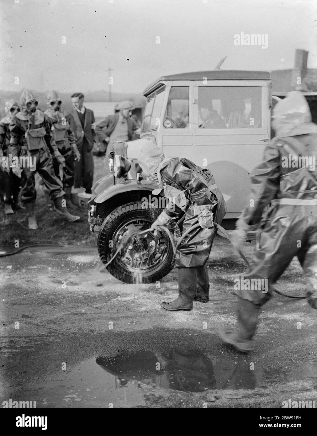 ARP ( air raid precautions ) demonstrations . Firemen at Green Street Green in protective clothing and gas masks , washing down their vehicles in a decontamination process . 5 March 1938 Stock Photo