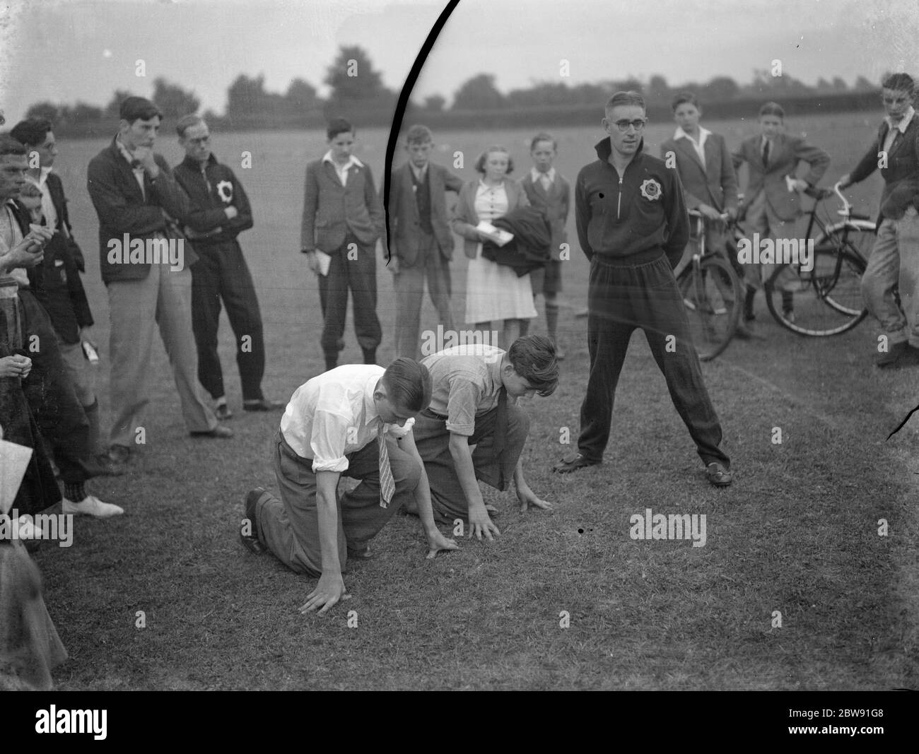 Sydney Wooderson , the great British middle distance runner and mile world record holder , teaches boys the sprinting start technique . 1939 Stock Photo