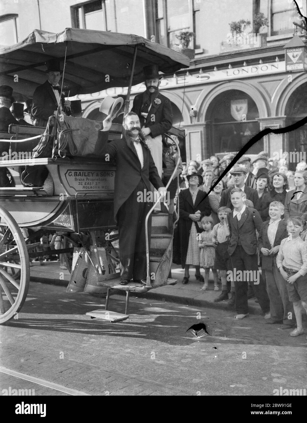 A gentleman waving to the crowds from an old stagecoach on the the High Street in Deptford , London . 1939 Stock Photo