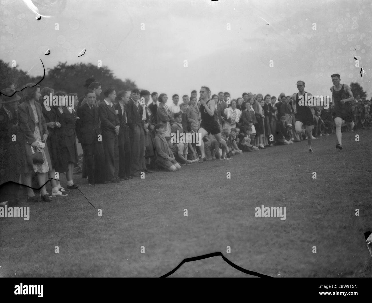 Sydney Wooderson , the great British middle distance runner and mile world record holder , teaches boys running technique . 1939 Stock Photo