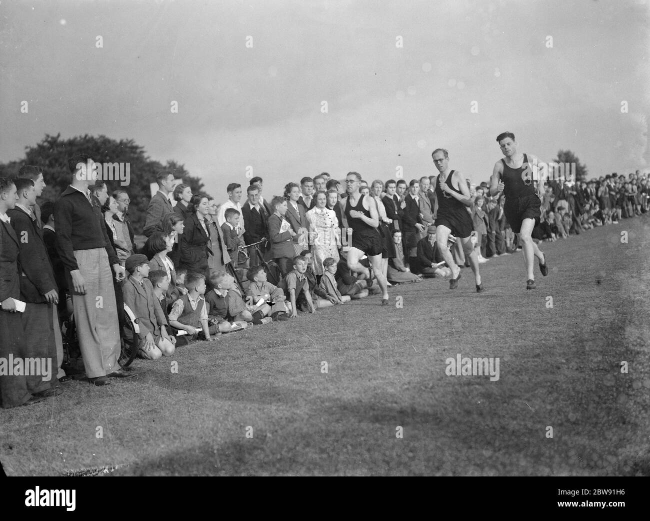 Sydney Wooderson , the great British middle distance runner and mile world record holder , teaches boys running technique . 1939 Stock Photo