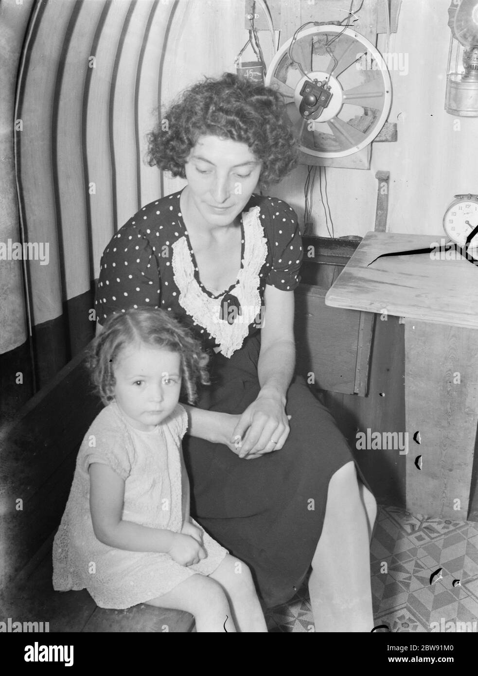 Mrs Ellis and Valerie Ellis sitting in an air raid shelter in Downham , Kent . 1939 Stock Photo