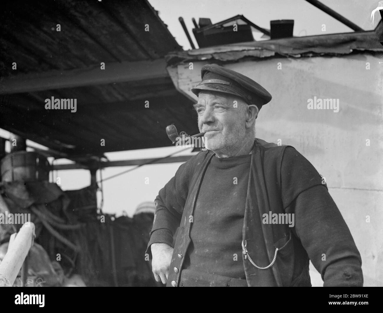 Mr W Rayfield , on the barge  Mocking Bird  smoking his pipe at Gravesend Reach . 1938 Stock Photo