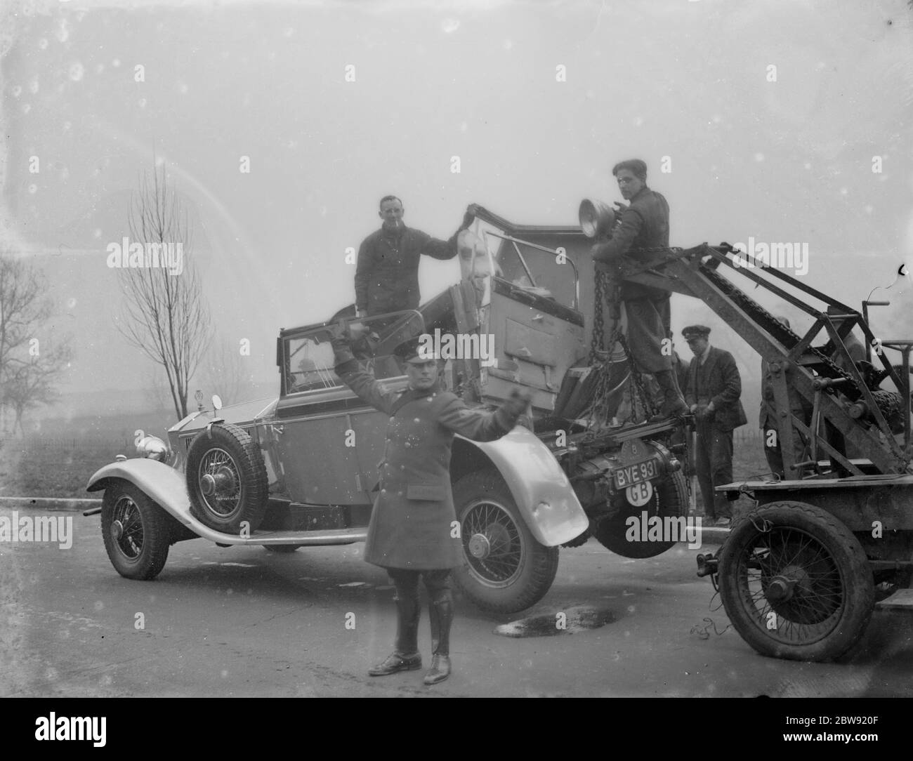 The damaged Rolls Royce being towed away after it had crashed with a lorry in Bexley , Kent . AA patrolman directs the traffic . 28 February 1936 Stock Photo
