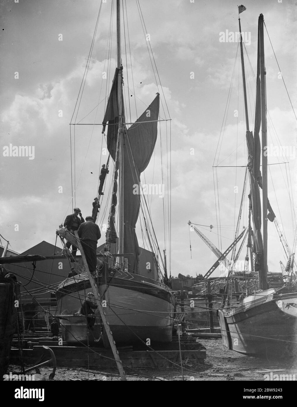 Men working on Thames sailing barges at low tide . 1938 Stock Photo