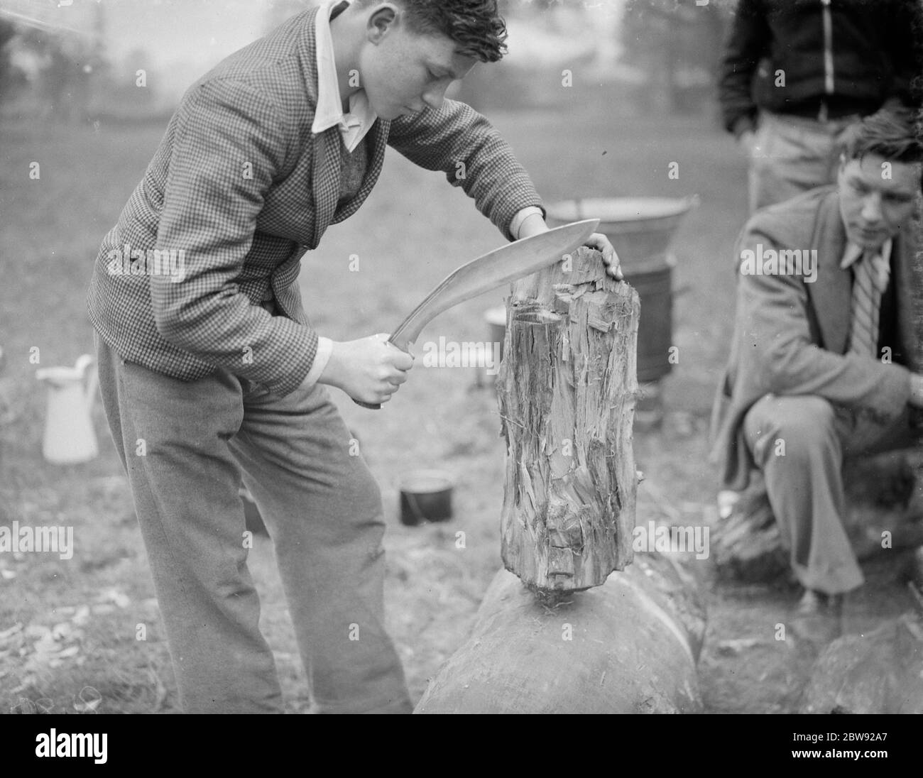 Chopping wood ( with a kukri , Nepalese knife ) at the Evening Institute camp at Frognal , Sidcup , Kent . 1938 Stock Photo