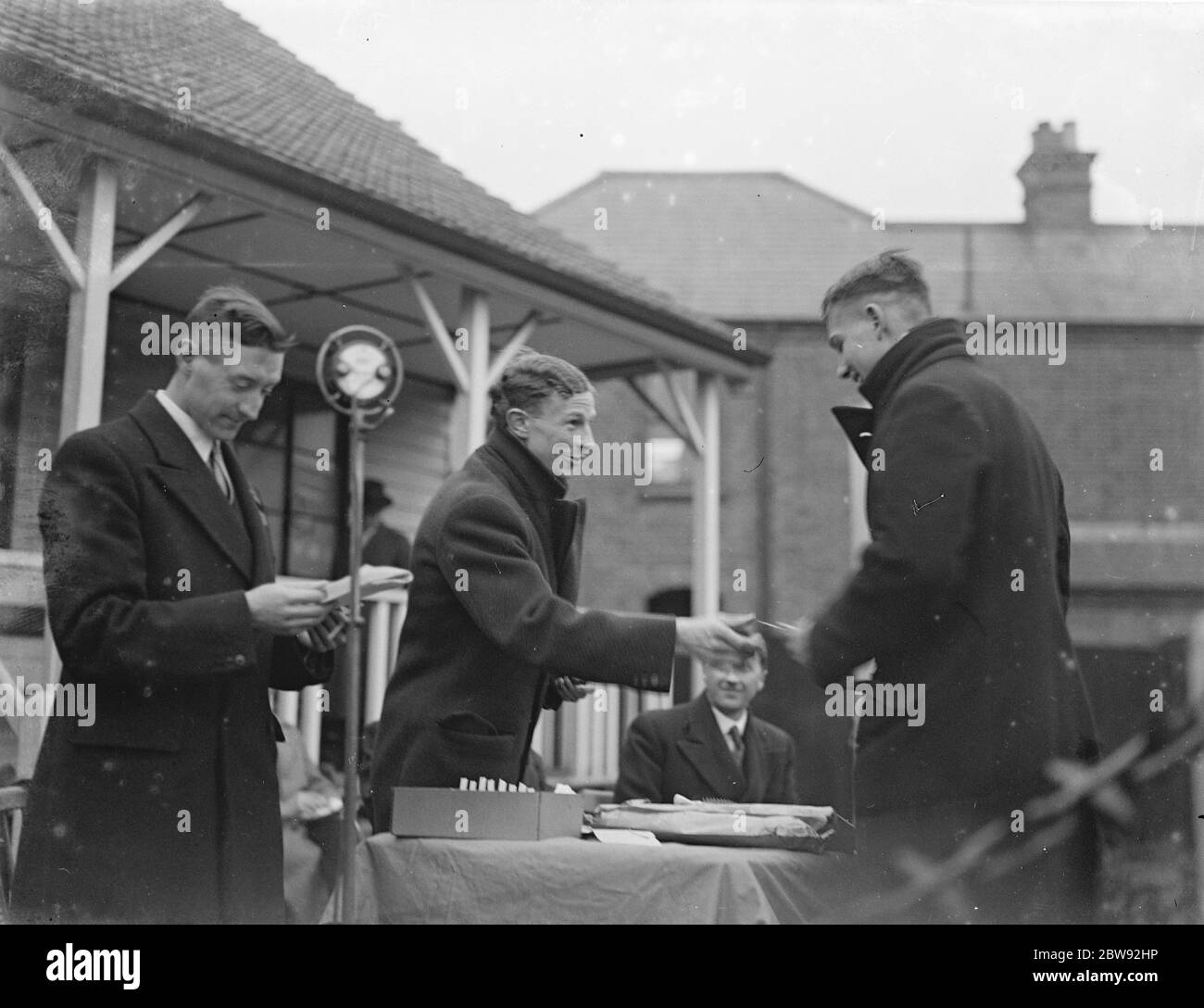 The Olympic 1500 meter gold medalist for New Zealand , Jack E Lovelock (center), gives out prizes at the Eltham College Sports Day . 1939 Stock Photo