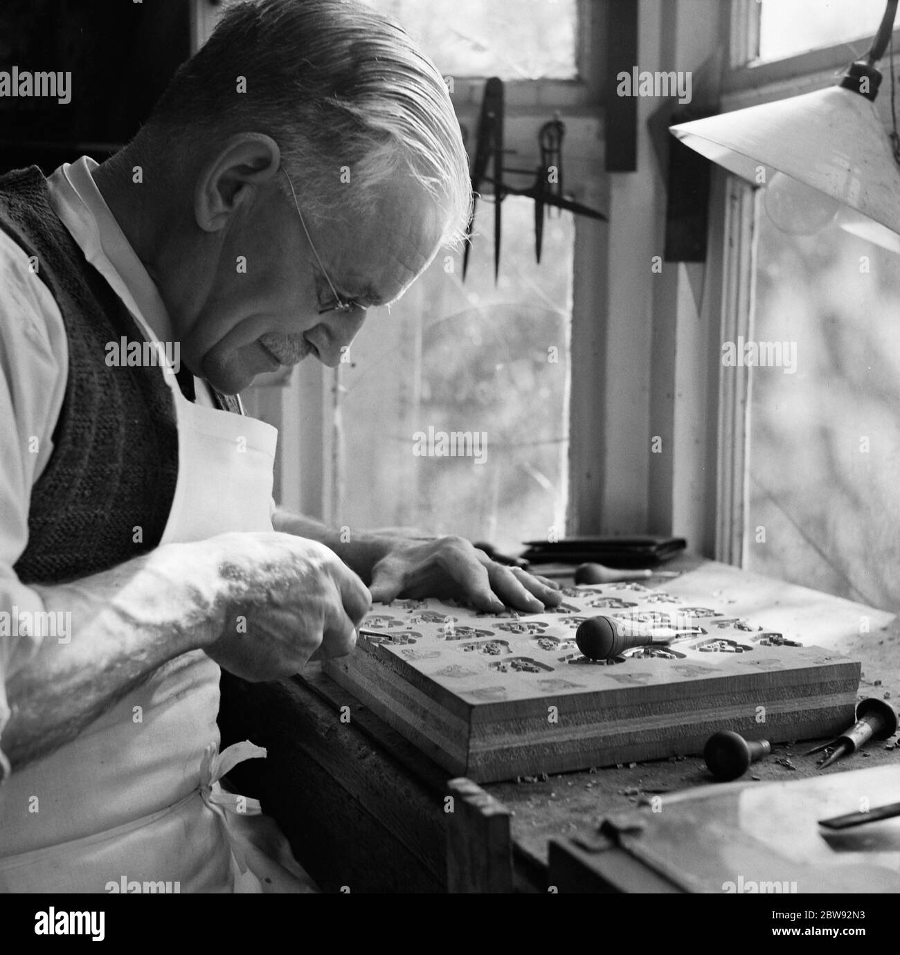 Block making in Wilmington , Kent . MR G E Campbell carving out dog head patterns . 27 April 1939 Stock Photo