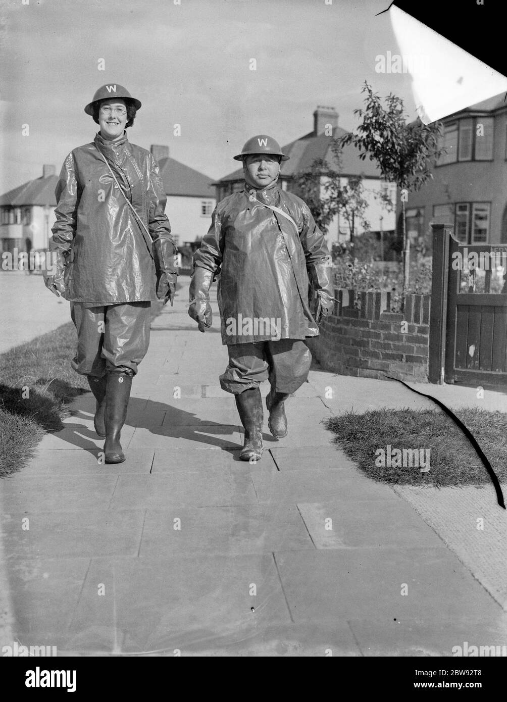 The tallest woman air raid Warden , Miss B Allnutt , walking down the street with a fellow Warden , Mr G A Boys . She stands at 6ft 2ins . 1939 Stock Photo
