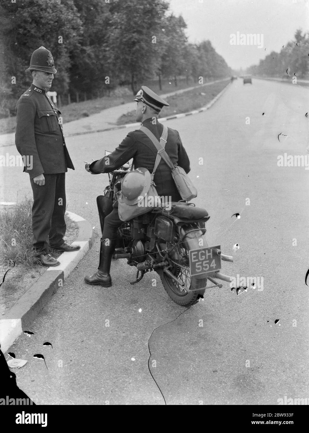Policeman exchanging words with a motorcyclist in ARP kit . 1939 Stock Photo