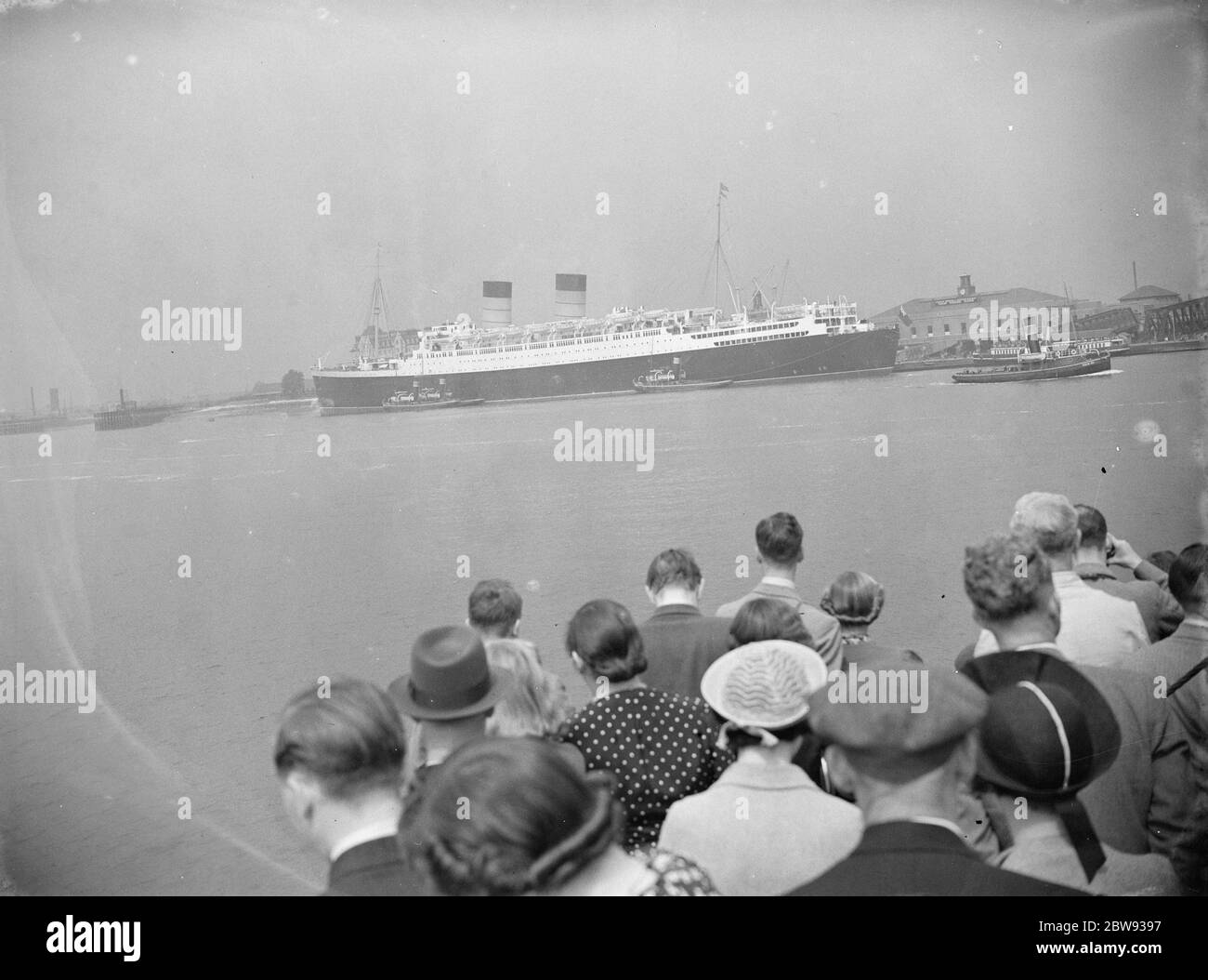 Crowds have gathered to see the RMS Mauretania which is lying in wait at Tilbury Dock in Essex . RMS Mauretania is an ocean liner designed by Leonard Peskett and built by Swan , Hunter & Wigham Richardson at Wallsend , Tyne and Wear , for the British Cunard Line . 1939 Stock Photo