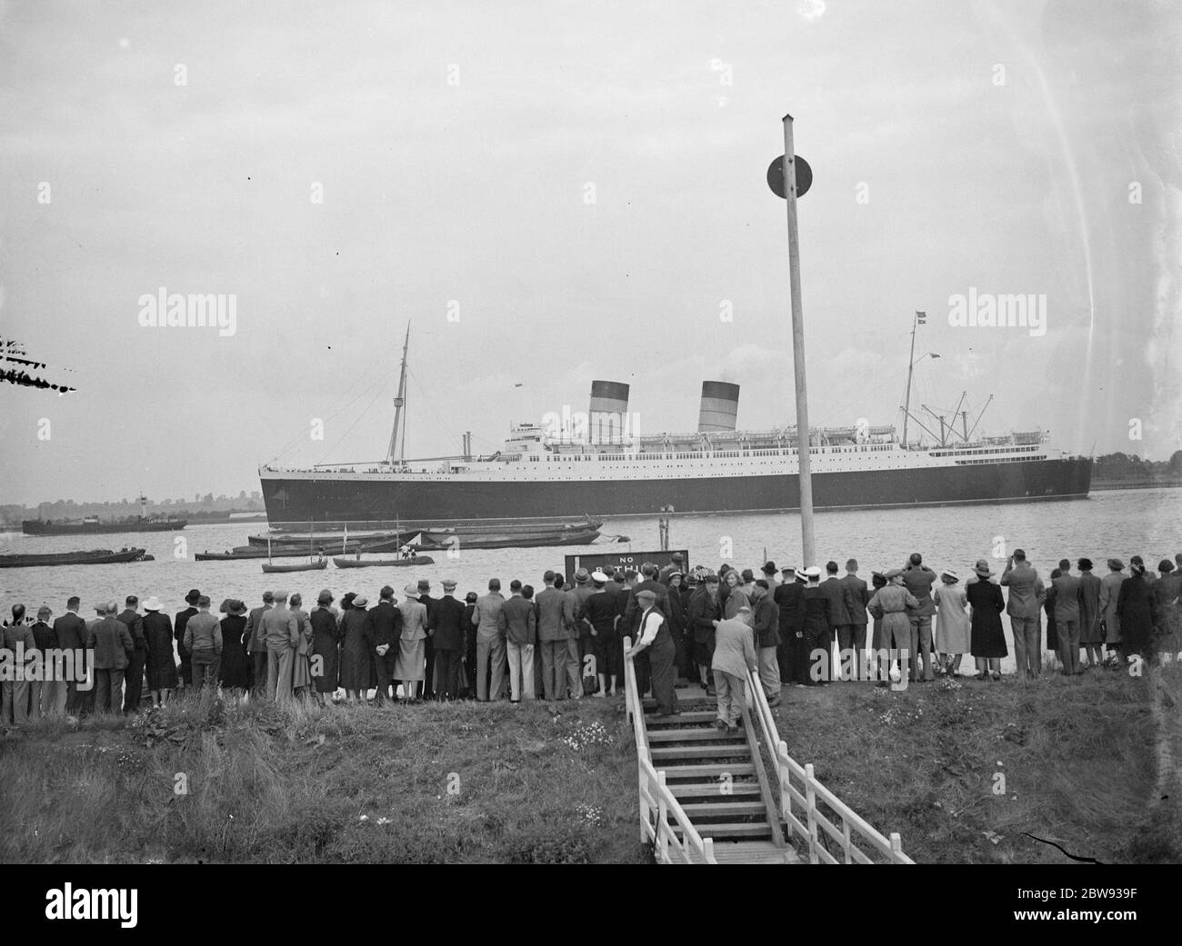 Crowds gather on the bank of the Thames estuary at Long Reach in Dartford , Kent , for a chance to spot the RMS Mauretania . RMS Mauretania is an ocean liner designed by Leonard Peskett and built by Swan , Hunter & Wigham Richardson at Wallsend , Tyne and Wear , for the British Cunard Line . 1939 Stock Photo