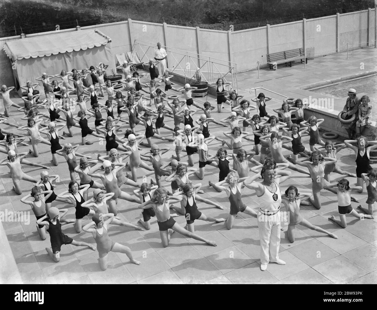 Children performing drills at the Swanscombe Baths in Kent . The instructor is Mr Bahalane . 1939 . Stock Photo