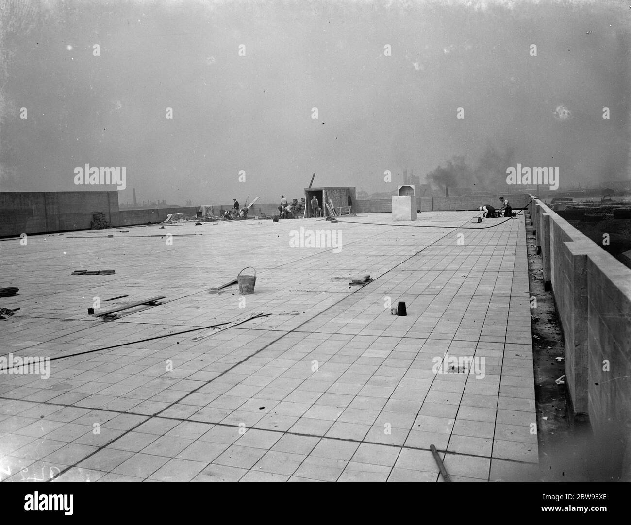 Workers from Val De Travers Asphalt Limited , a paving company , working on a roof in Greenwich , London . 1938 Stock Photo