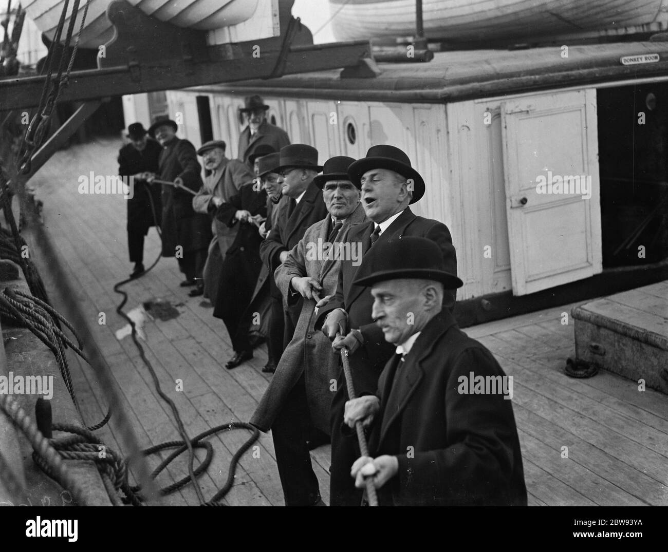 Old salts visit the Cutty Sark in Greenhithe , Kent . The old salts pull the rigging rope . Commander Irving is 2nd from front . 1938 . Stock Photo