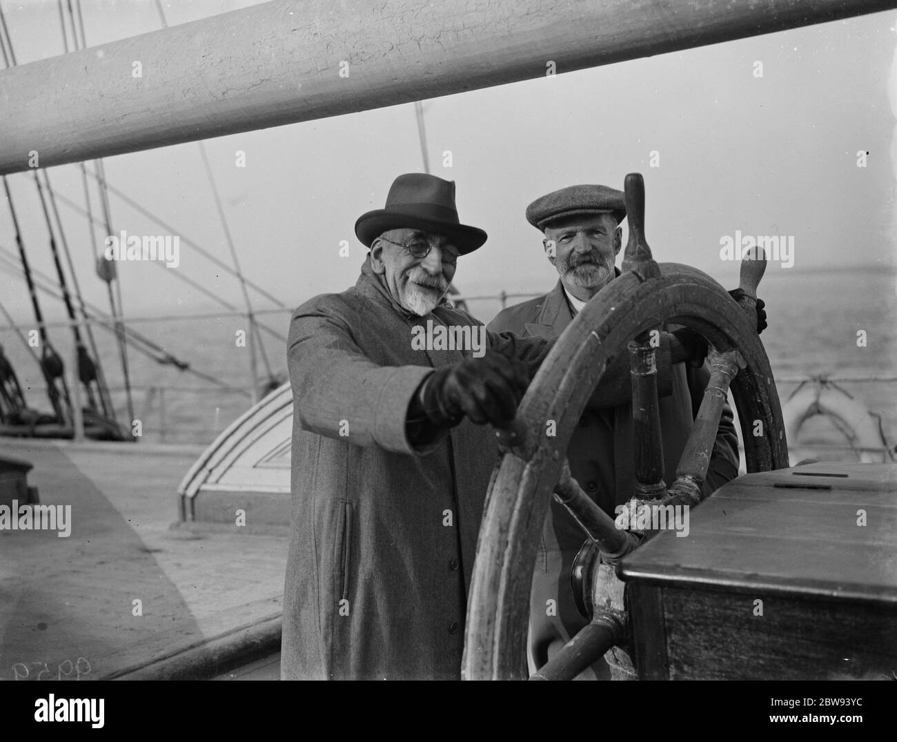 Old salts visit the Cutty Sark in Greenhithe , Kent . Commander J J W Calderon and Mr C Macdonald at the wheel . 1938 . Stock Photo