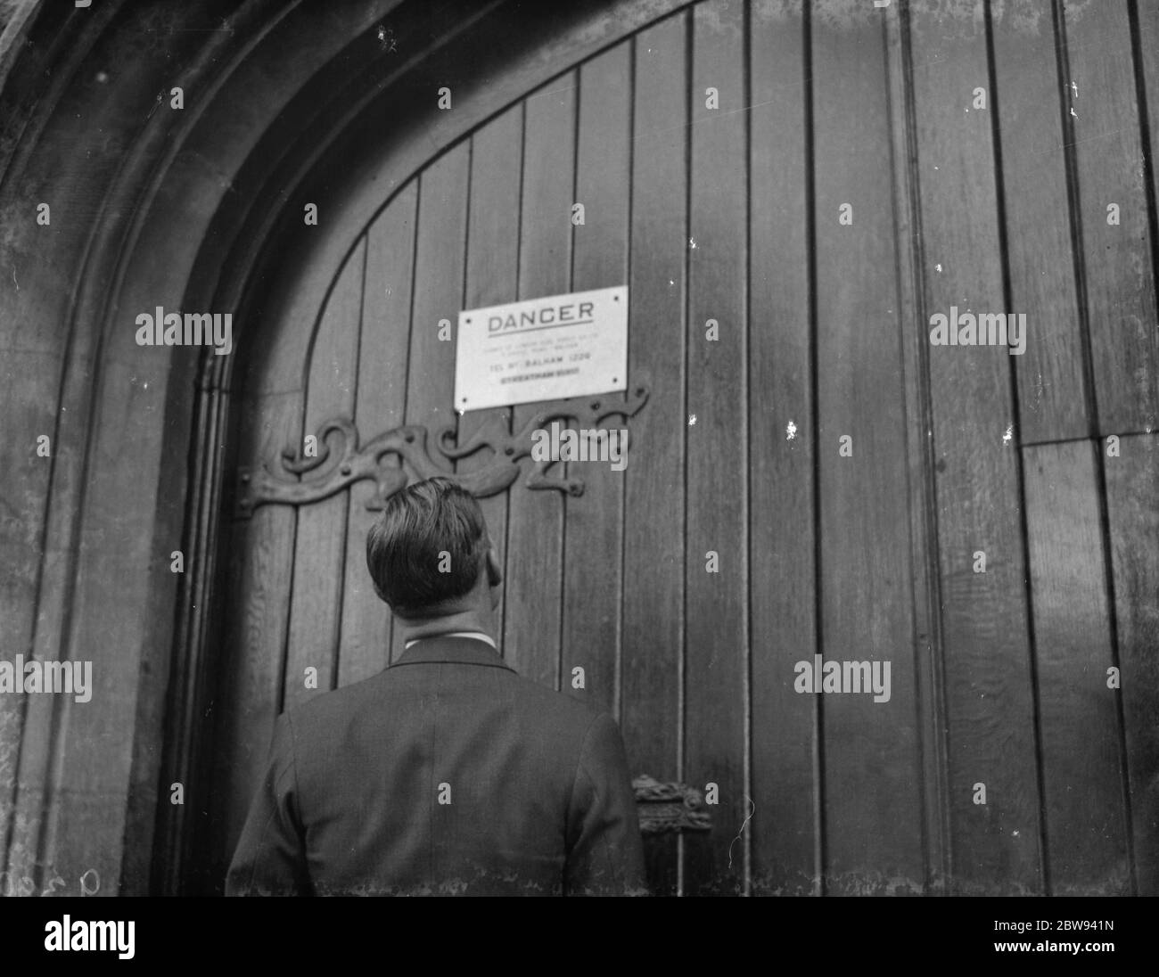 A warning sign on the door of a church building where an electric transformer station housed in Streatham , London . 1938 Stock Photo