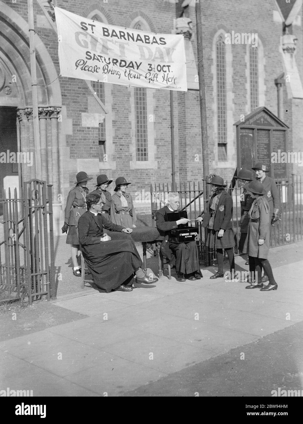 A little girl gives money to the collectors for St Barnabas Church in Eltham , Kent . 1938 Stock Photo
