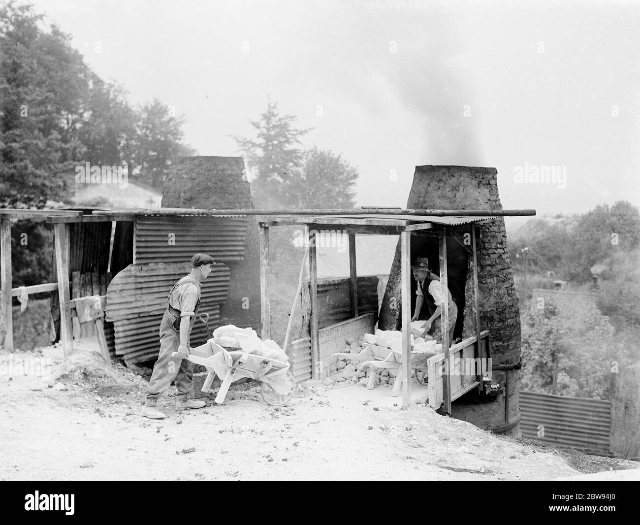 The Lime Works in Dunton Green , Kent . Men pile lime blocks into the kilns . 1938 . Stock Photo