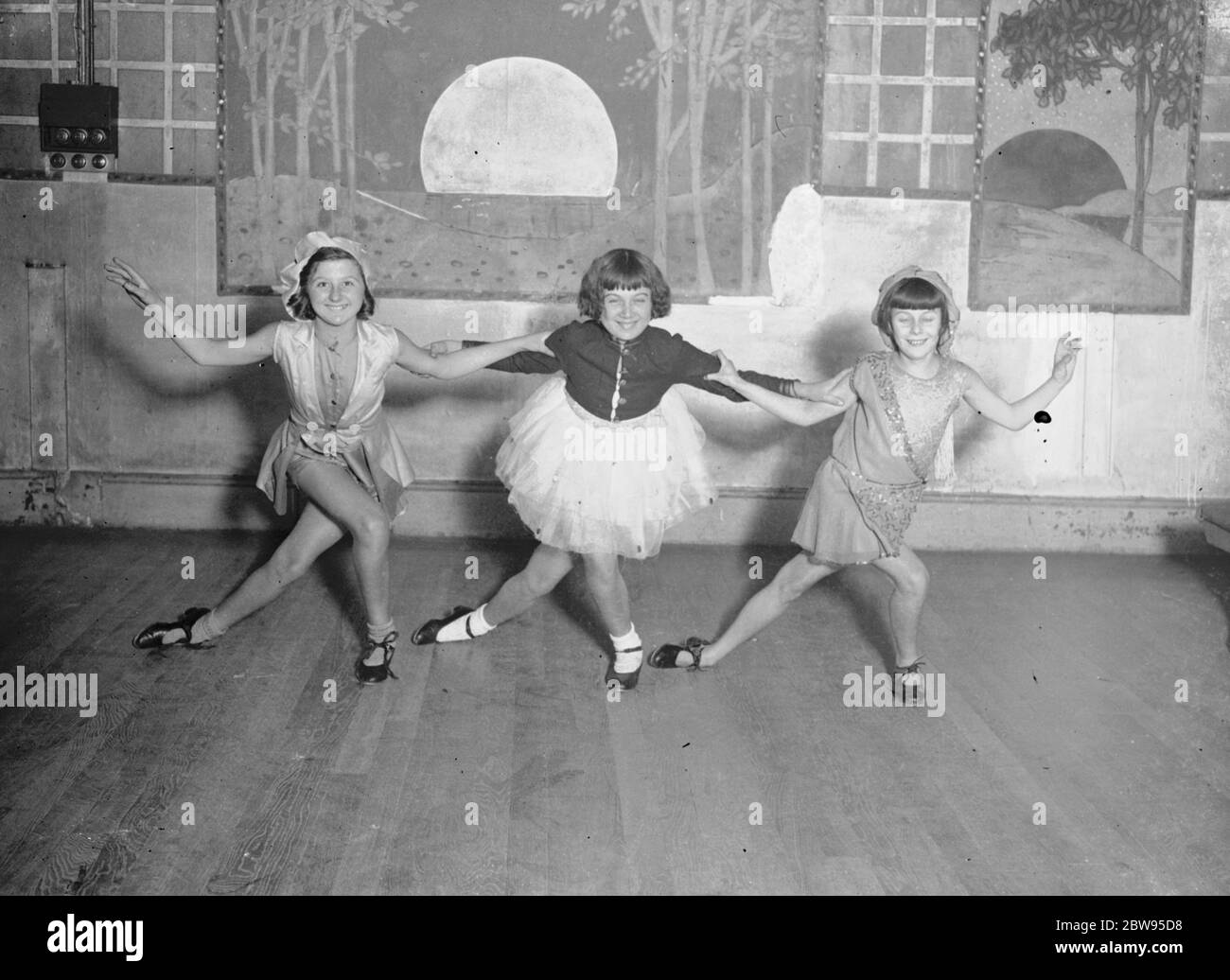 Youthful dancers prepare for the pantomine . A great future is promised for these three trick dancers , whose clever footwork on the stage , and their acrobatic tricks are admired by experts in the art . They are Vera Polton aged 12 , Mauzie Rogers aged 12 and Dolly Bond aged 13 and are rehearsing under the direction for Harry Dennis at a London dancing academy for a pantomine show . Vera Polton , Mazie Rogers , and Dolly Bond rehearsing for a Christmas pantomine at a London academy . 9 November 1932 Stock Photo