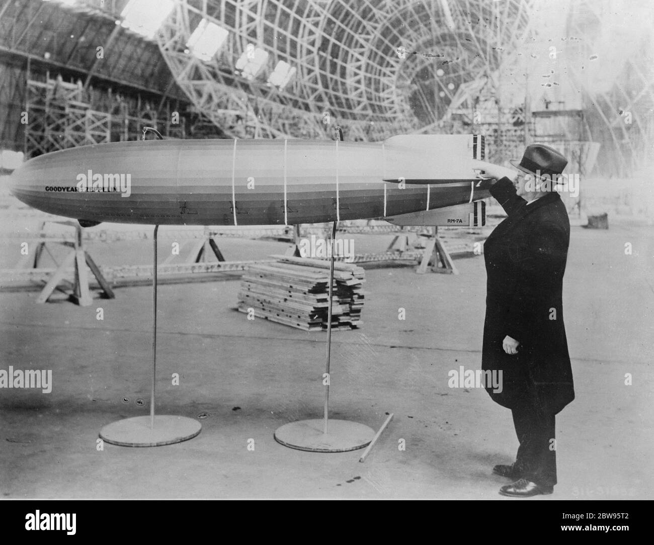 Model of giant new dirigible shows progress of work . Dr Karl Arnstein , designer of the US Navy airships Akron and Macon , pointing out in his model the position in the hull of the sixth main frame which was recently put into place on the Macon , which is now being built at the Goodyear Zepplin dock at Akron , Ohio . White lines indicate the number of main frames erected to date and their positions in the hull . 30 March 1932 Stock Photo