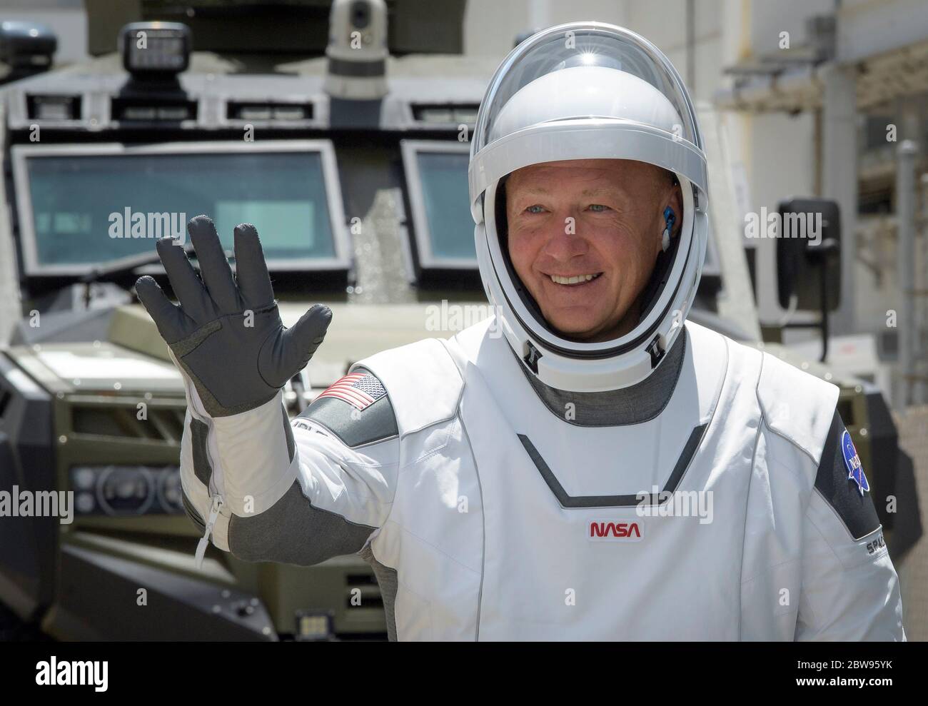 In this photo released by the National Aeronautics and Space Administration (NASA), NASA astronaut Douglas Hurley waves as he and fellow crew member Robert Behnken depart the Neil A. Armstrong Operations and Checkout Building for Launch Complex 39A to board the SpaceX Crew Dragon spacecraft for the Demo-2 mission launch, Saturday, May 30, 2020, at NASA's Kennedy Space Center in Florida. NASA's SpaceX Demo-2 mission is the first launch with astronauts of the SpaceX Crew Dragon spacecraft and Falcon 9 rocket to the International Space Station as part of the agency's Commercial Crew Program. The Stock Photo