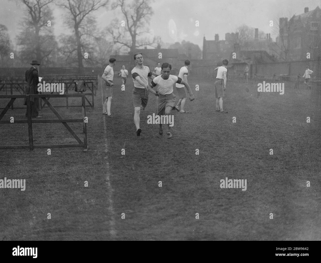 Prince Birabongse changes over in relay at Eton College sports . Prince Birabongse taking over from G Cox in the Inter House relay of the Eton College Sports final at Windsor . 22 March 1932 Stock Photo