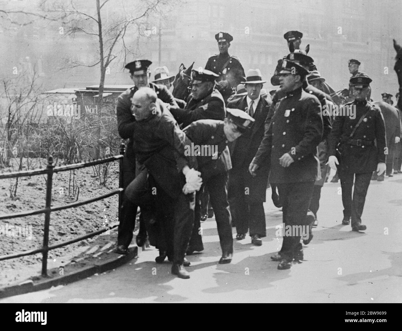 Women reds fight police in communist demonstration in New York . After marching in two lines in opposite directions around the City Hall , New York , demanding to see Mayor Walker , Communists demonstrated outside the building and police were compelled to charge them before they would disperse . Police fighting with women communists outside the city Hall , New York . 29 April 1932 Stock Photo