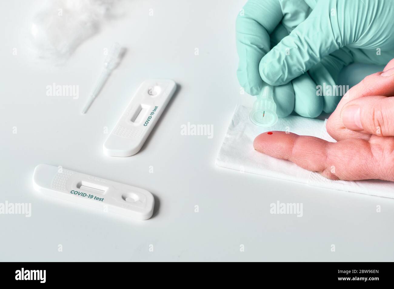 Rapid COVID-19 test for detection of specific antibodies IgM and IgG to novel corona virus SARS-CoV-2, Covid-19. Patient finger for analysis. Gloved n Stock Photo