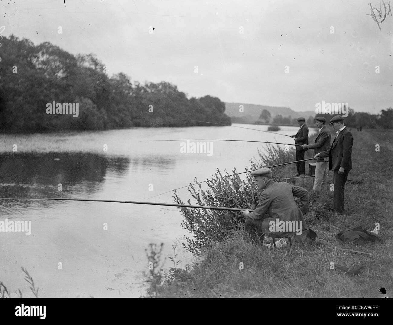 The first catch at Pangbourne fishing festival . Hundreds of fisherman of all ages took part in a great festival , on the river Thames at Pangbourne , Berkshire . Three anglers fishing on the Thames bank at Pangbourne during the festival . 23 July 1932 Stock Photo