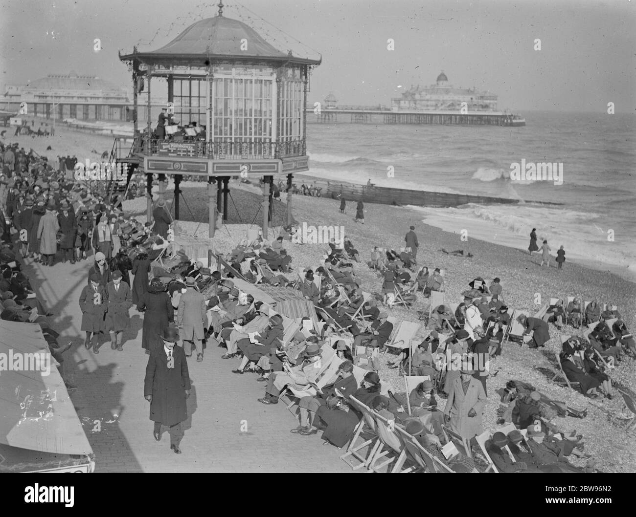 Holiday beach loungers at Eastbourne . So warm has been the weather on the south coast that visitors have been enjoying the sunshine and sea breezes lounging on the beach . The scene on the beach at Eastbourne in the sunny weather .27 March 1932 Stock Photo