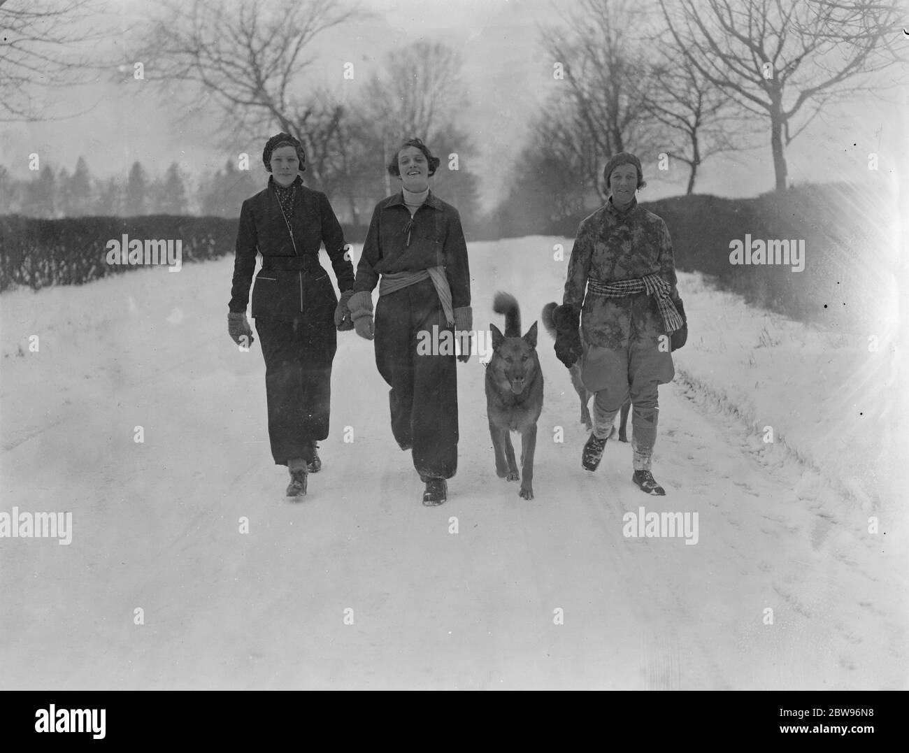 Winter sports fashion in Surrey , Mrs Freshfield ( right ) with her daughter Miss Zoe Freshfield ( centre 0 and Miss Norah Taylor in the latest in winter sports costumes off to enjoy a run in the snow on the slopes of the Surrey Hills near Reigate . 11 February 1932 Stock Photo