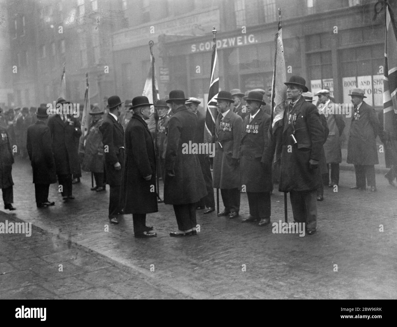 Aldgate old comrades association standard dedication . The Aldgate Old Comrades association standard was dedicated at St Johns Church Aldgate , London . Major E Edwards ( left ) talking to members of the old comrades association at the parade . 14 February 1932 Stock Photo